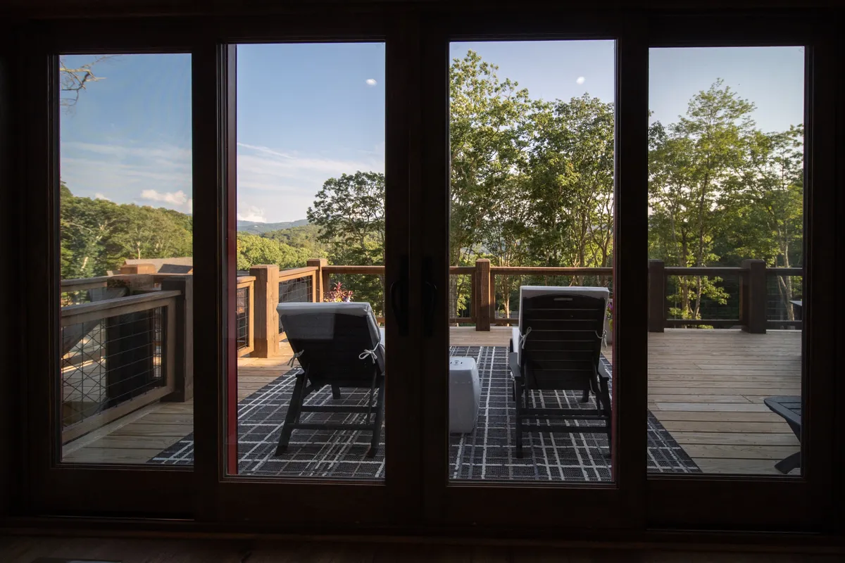 An outdoor deck scene with lounge chairs overlooking a stunning mountain view, ideal for relaxation, yoga at sunrise, or simply soaking in the natural beauty of the High Country.