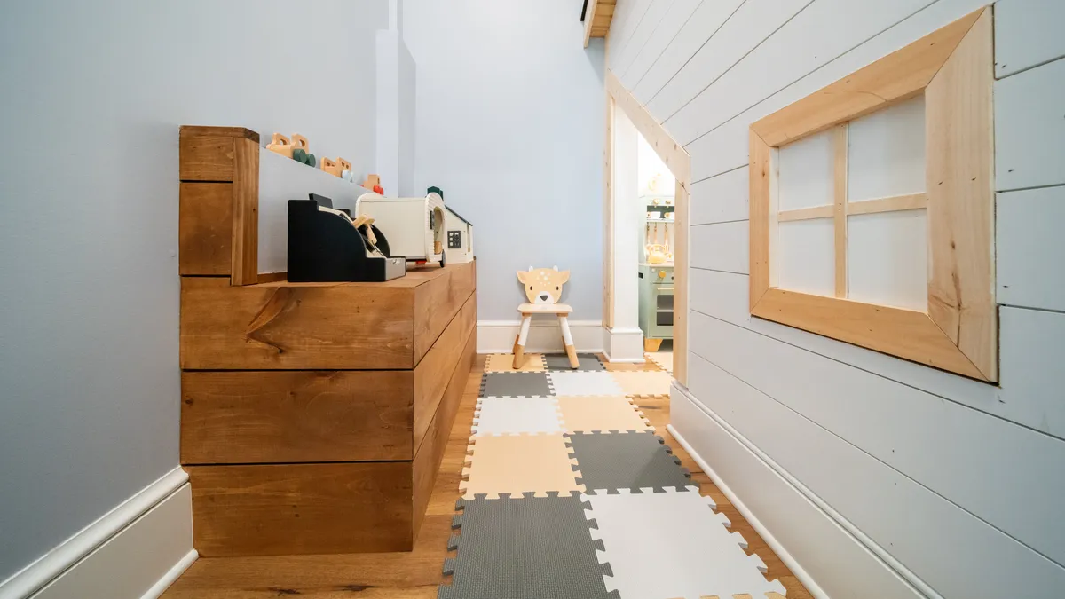 A cheerful, kid-friendly corner featuring a wooden dresser, playful toys, and a child's chair, evoking a nurturing and imaginative atmosphere ideal for younger children.